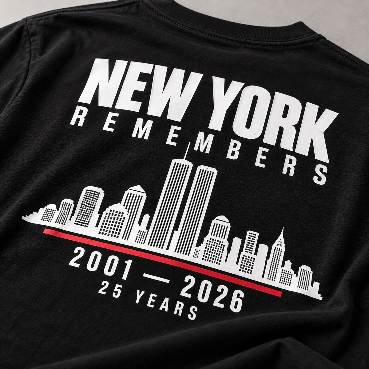 Detail of white skyline and red divider print on black New York Remembers T-shirt